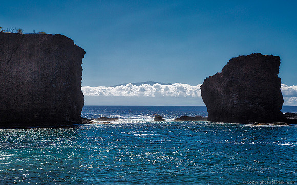 Puu Pehe Rock, Lanai with Maui above the clouds