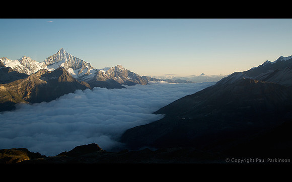 Sunrise over Mattertal, with Zermatt in valley below beneath clouds